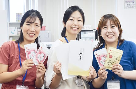 笑顔で商品を紹介するスタッフ3名